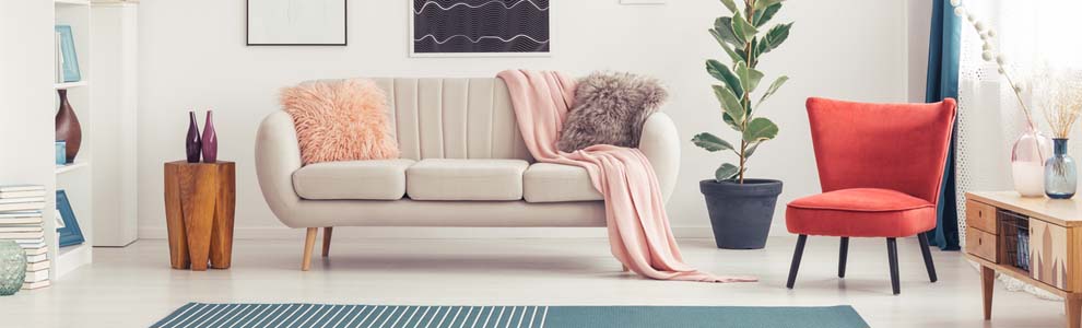 White couch with pink blanket and furry pillows